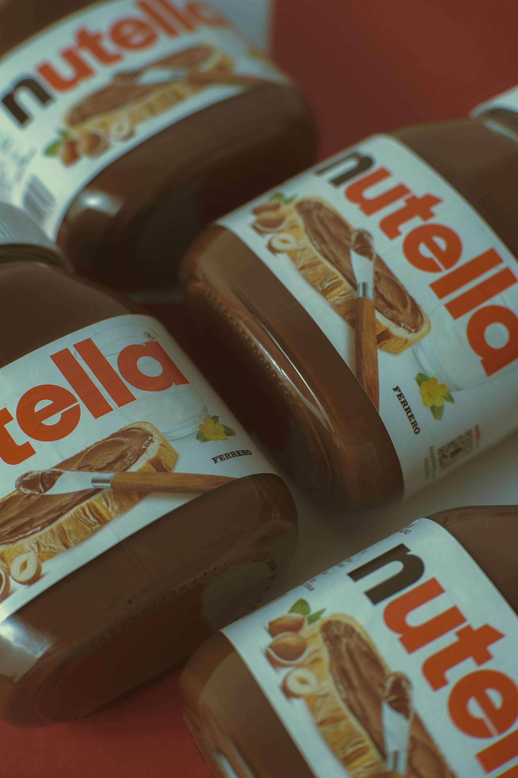 Four Nutella jars in a close-up shot showing chocolate spread details.